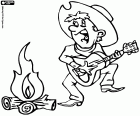 Ein Cowboy, singen, tanzen und spielen der Gitarre neben dem Lagerfeuer des Lagers in der Nacht